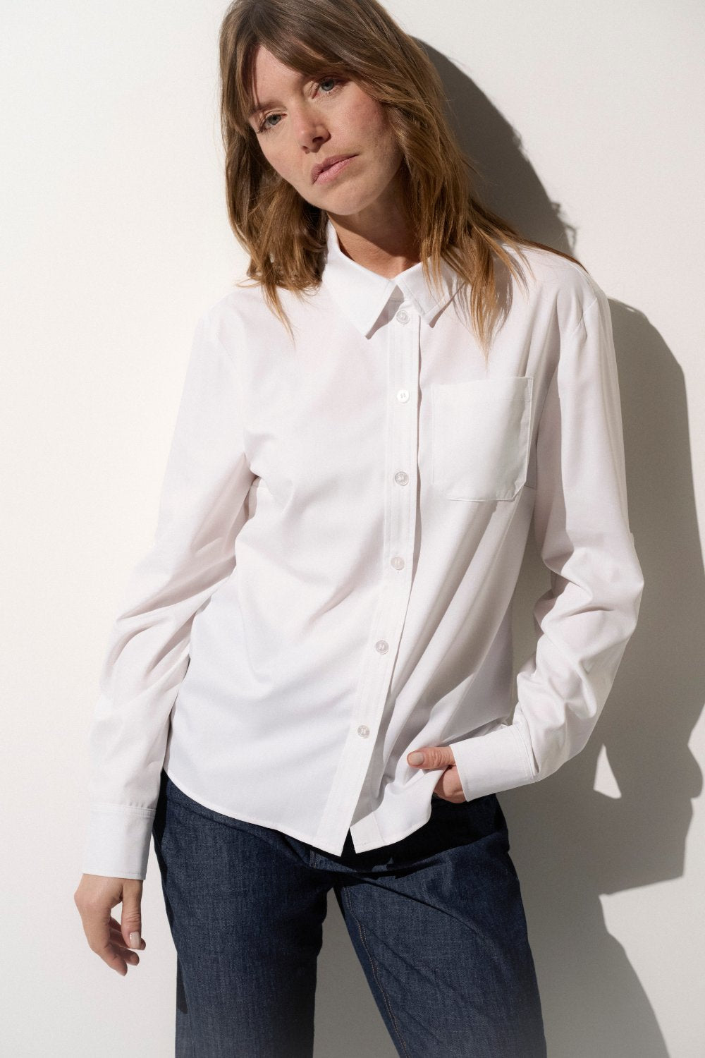 Chemise anti-UV blanche UPF50+ pour femme, élégante et légère, idéale pour une protection solaire quotidienne.