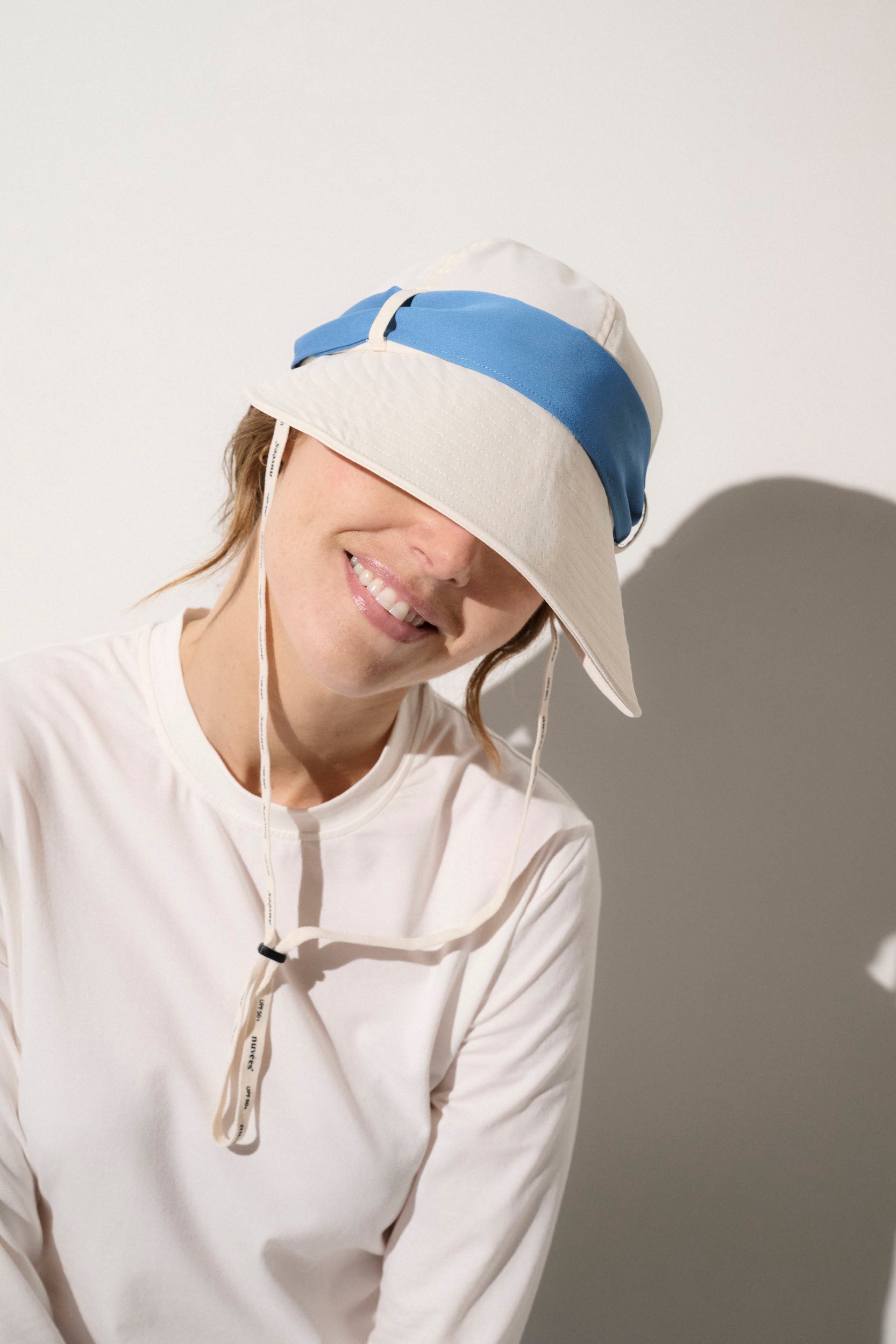 Casquette anti-UV beige et bleue UPF50+ pour femme, idéale pour une protection solaire élégante en plein air.