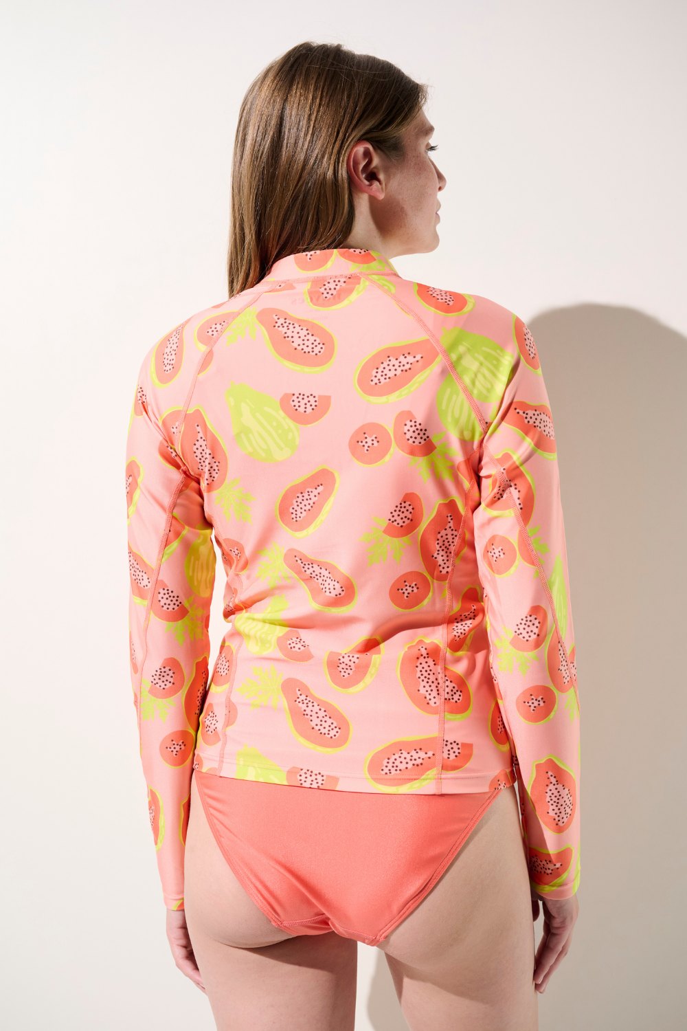Femme de dos portant une veste de bain anti-UV adaptée à la baignade et autres activités aquatiques.