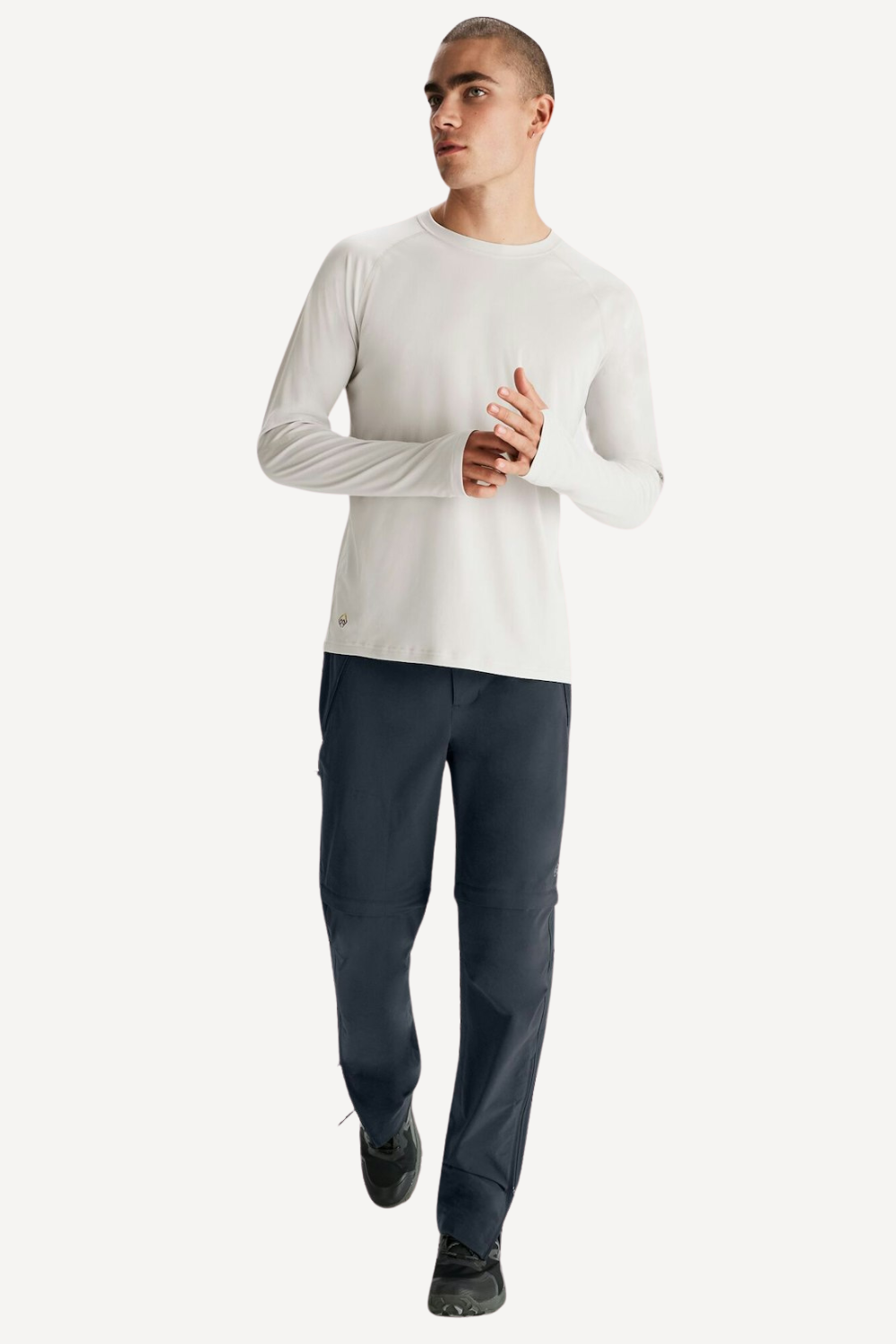 Homme portant un pantalon anti-UV bleu et un t-shirt blanc, léger et confortable avec protection solaire UPF 50+.
