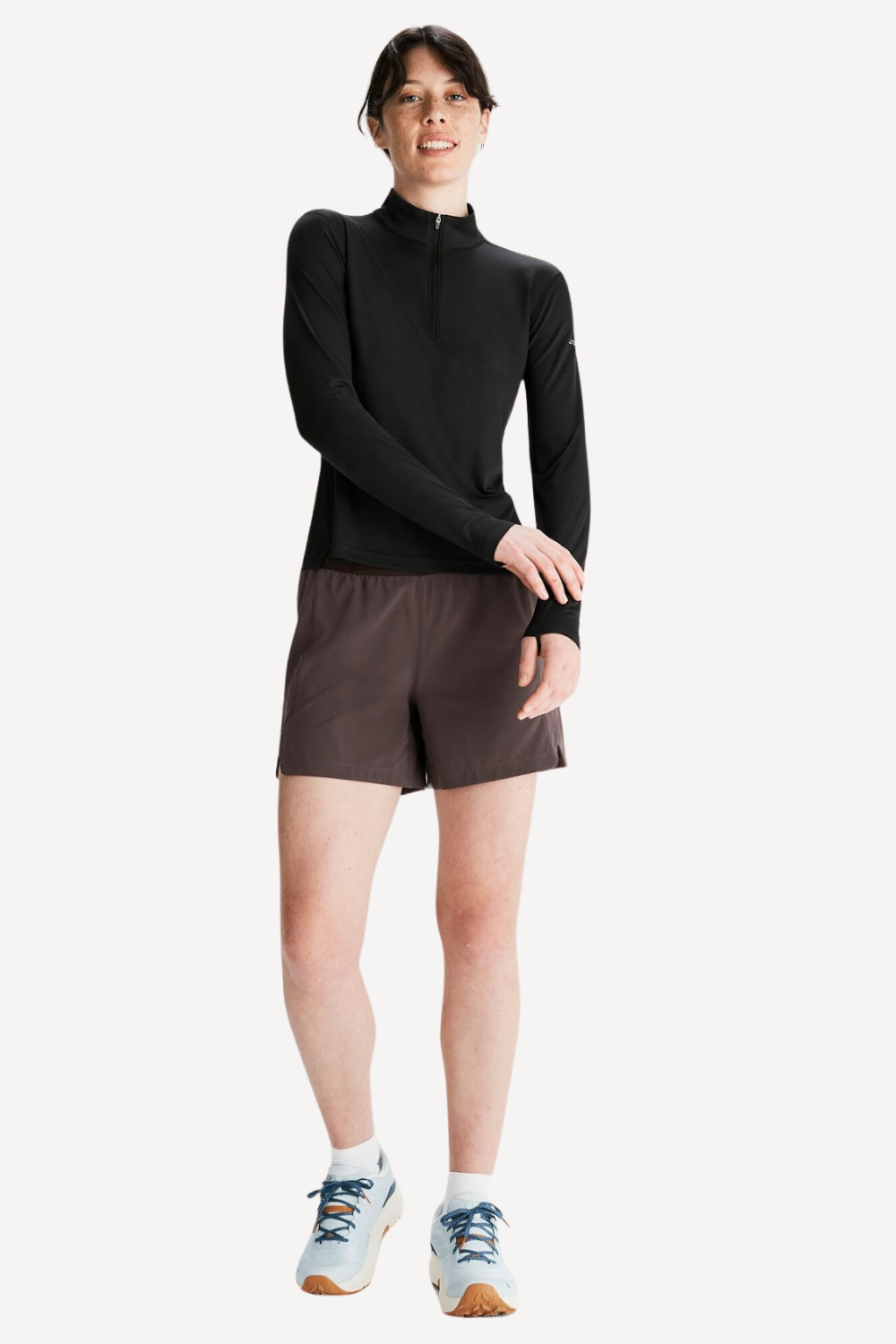 Femme en t-shirt anti-UV noir à manches longues, UPF 50+, porté pour une activité sportive en extérieur.