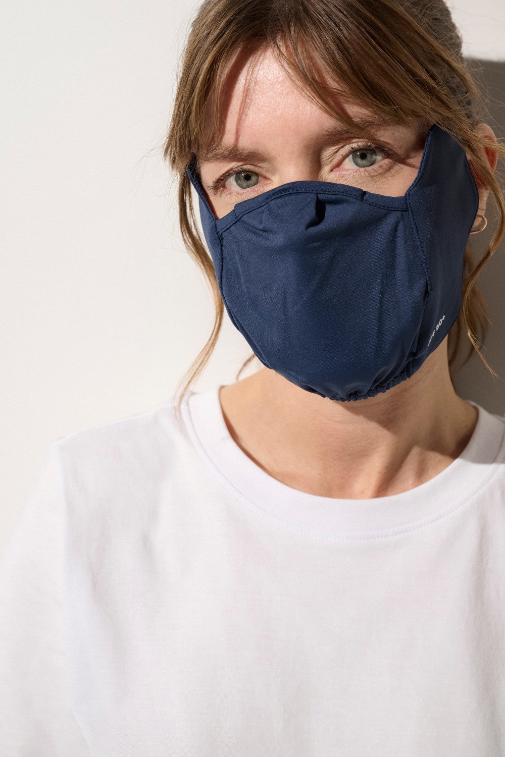 Masque anti-UV bleu pour femme, ajustement confortable et protection solaire UPF 50+, idéal pour peaux sensibles.