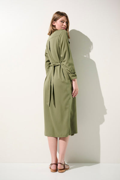 Femme portant la robe-chemise anti-UV - Rimini en kaki, élégante avec ceinture, idéale pour la protection solaire.