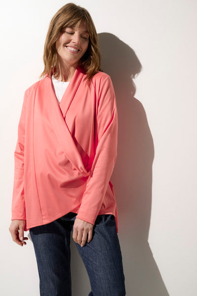 Femme portant un cache-cœur anti-UV rose, léger et respirant, offrant une protection solaire UPF50+.