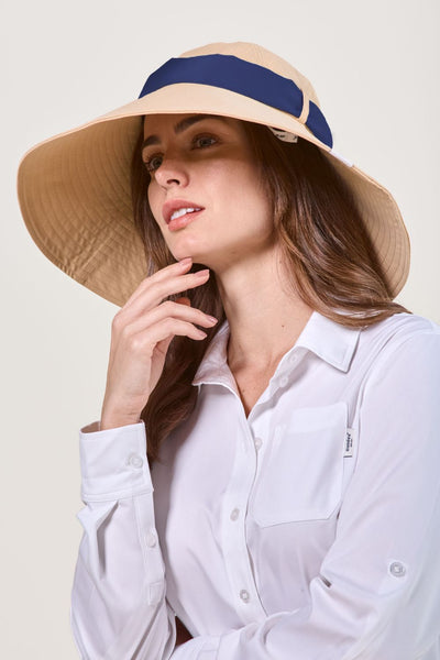 Femme portant un chapeau anti-UV à bord large, de couleur beige et certifié UPF 50+