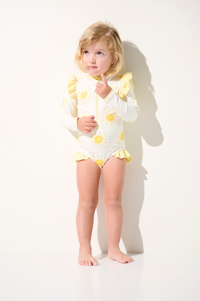 Maillot de bain anti-UV manches longues - Flores pour enfant, jaune avec motifs soleil, idéal pour la protection solaire.