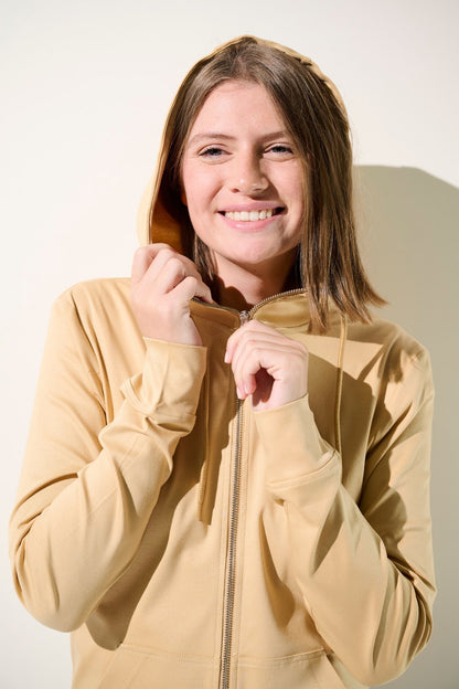 Veste à capuche anti-UV femme beige, légère et confortable, conçue pour une protection solaire UPF 50+.