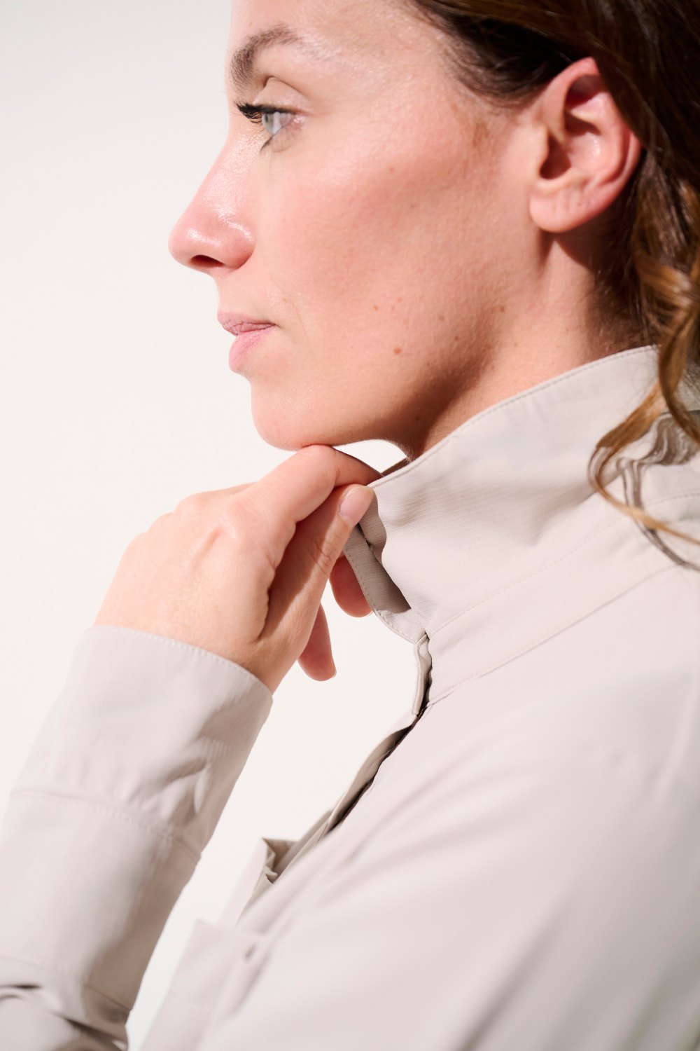 Femme portant une chemise anti-UV beige, confortable avec protection UPF 50+, idéale pour les activités en extérieur.