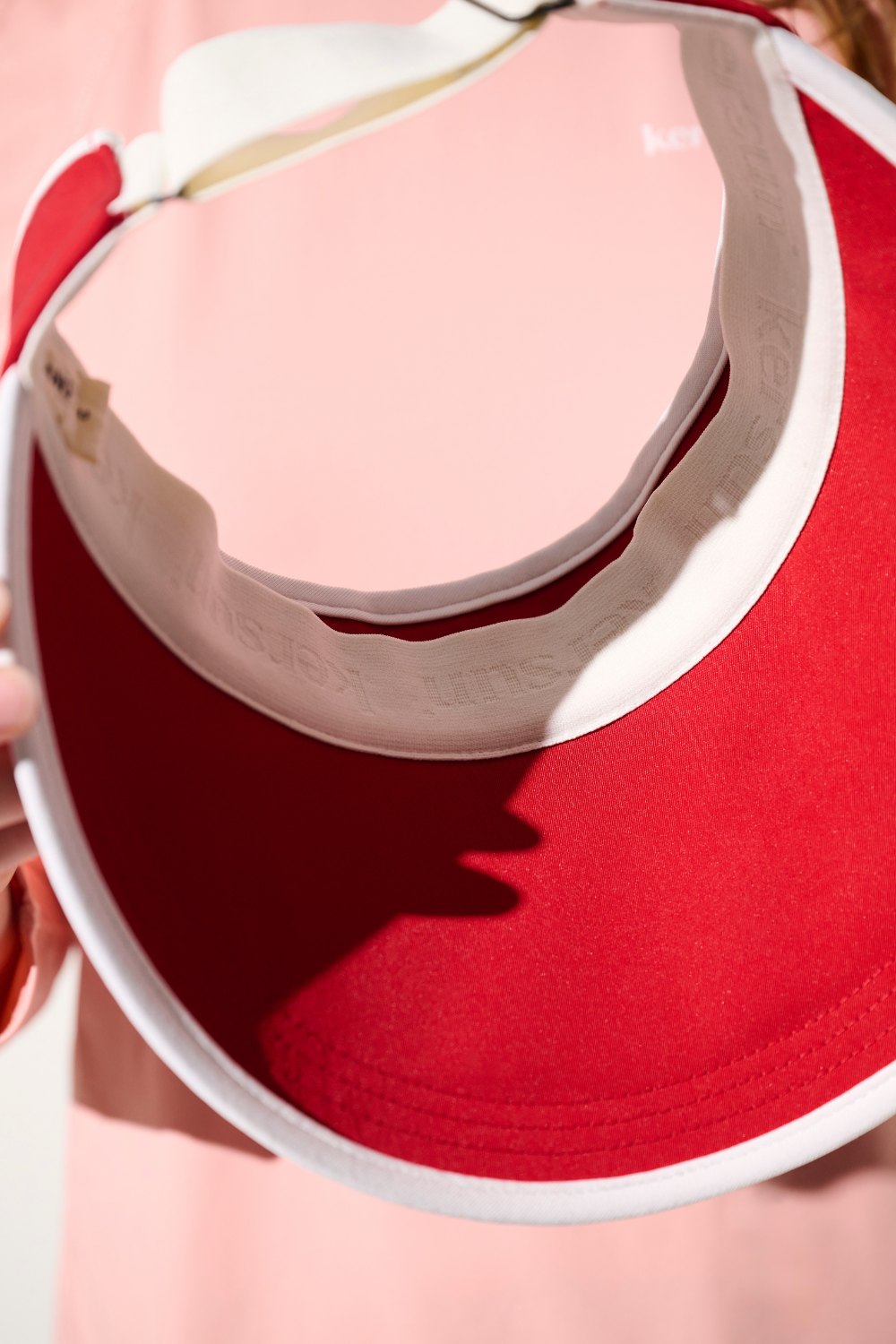 Visière anti-UV rouge UPF 50+ pour femme, idéale pour le sport et la protection solaire.