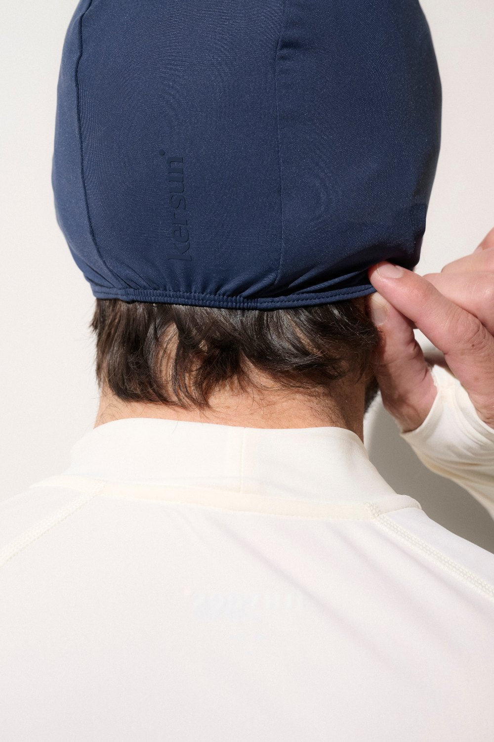 Bonnet de bain anti-UV bleu marin UPF 50+ pour homme, adapté à la protection solaire en milieu aquatique.