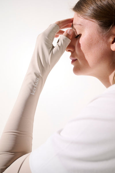 Femme portant des mitaines à manches anti-UV couleur beige, UPF 50+, pour une protection solaire élégante au quotidien.