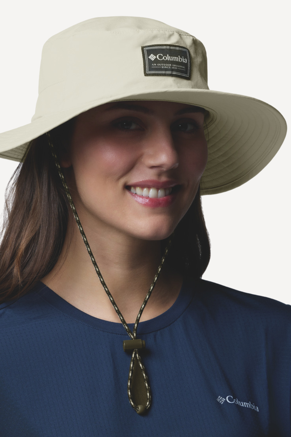 Chapeau anti-UV Columbia beige UPF 50+ porté par femme, parfait pour la protection solaire en extérieur.
