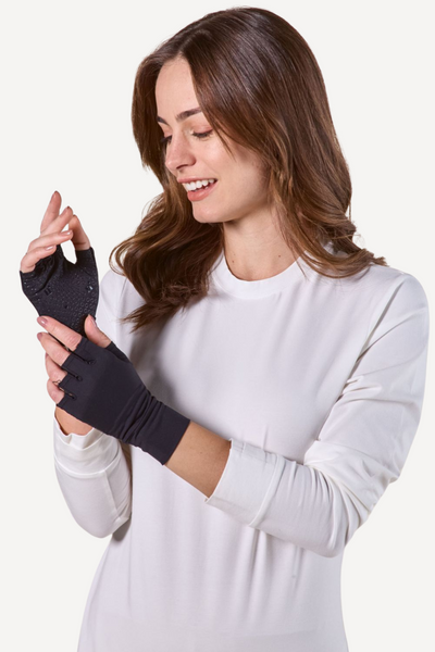 Femme souriante portant des mitaines anti-UV Gobi noires, adaptées aux activités en extérieur et à la protection solaire.