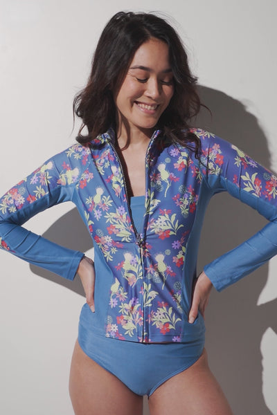 Veste de bain anti-UV - Moorea, bleue à fleurs, pour femme, UPF 50+, confortable et élégante pour les activités aquatiques.