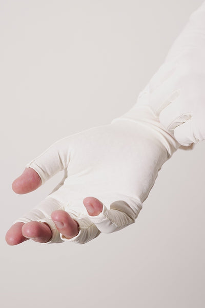 Mitaines anti-UV blanches UPF 50+ pour femme, offrant confort et protection solaire lors d'activités extérieures.
